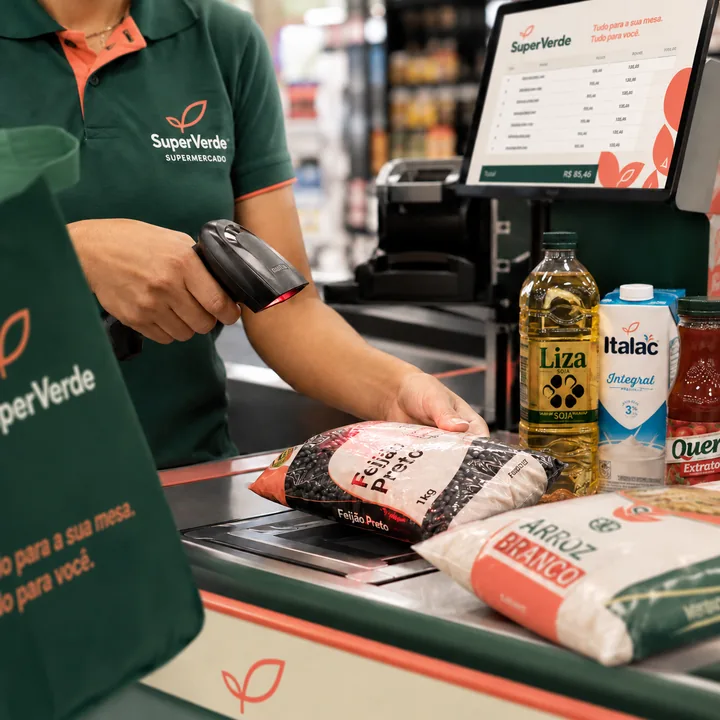 Operadora de caixa passando as compras no leitor de código de barras